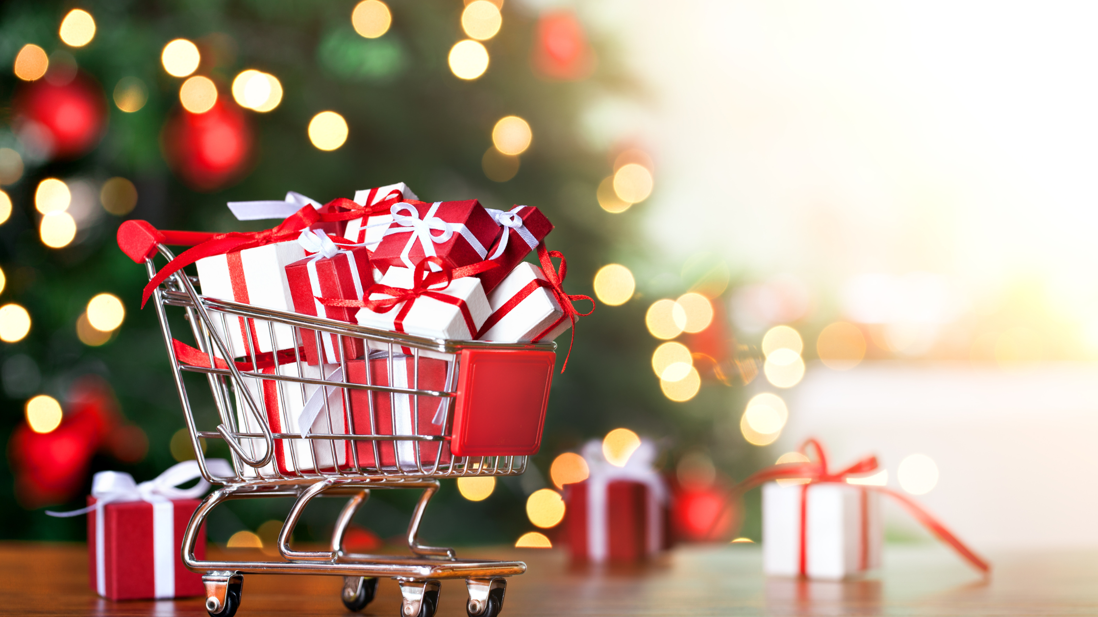 Red and White Gift boxes on a shopping cart with lights in the blurred background